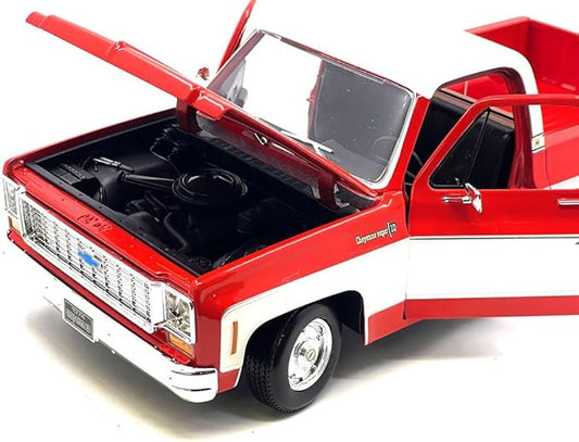 Model red pickup truck with open hood on a white background